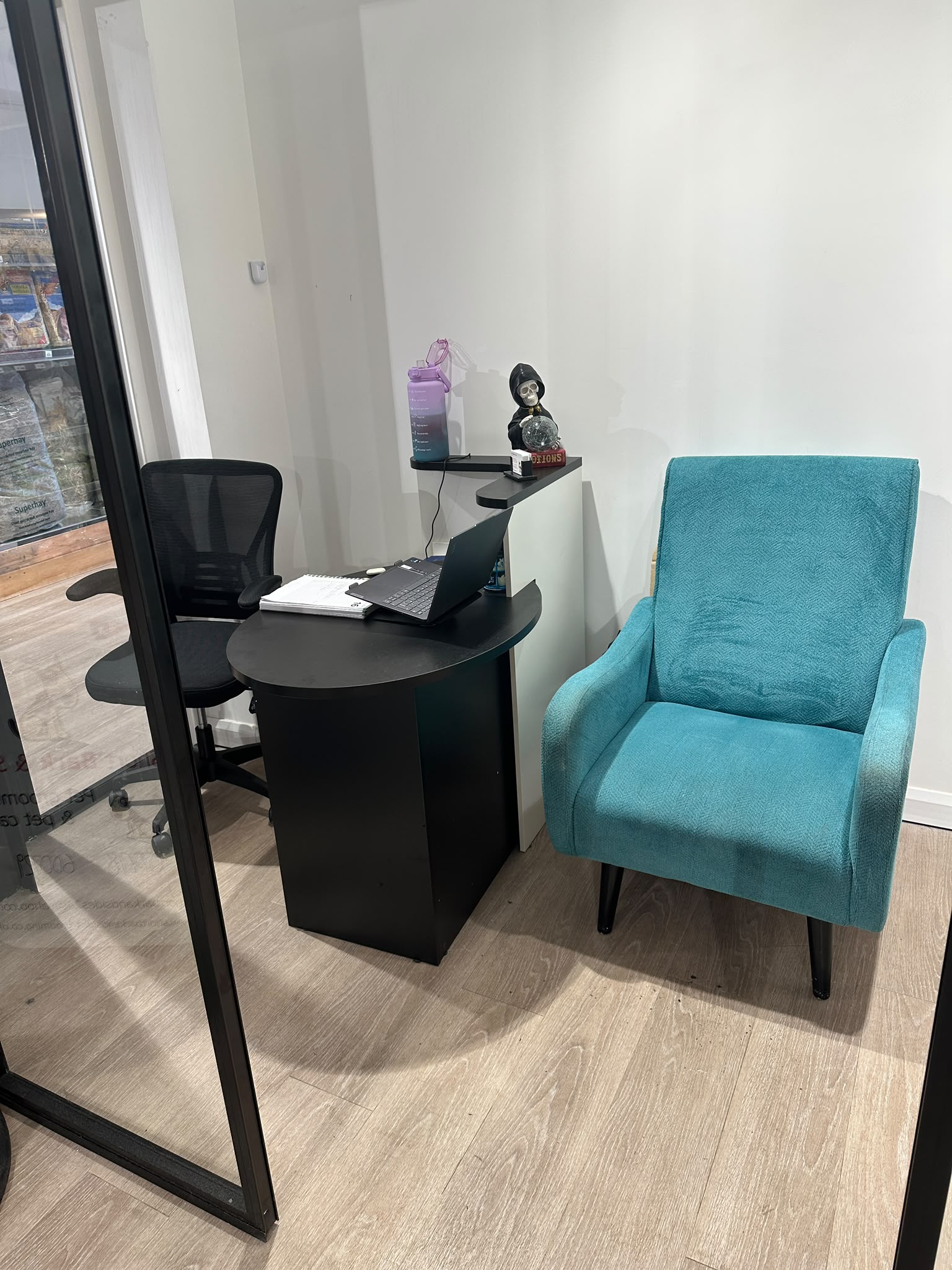 The salon's reception corner with a comfy teal armchair