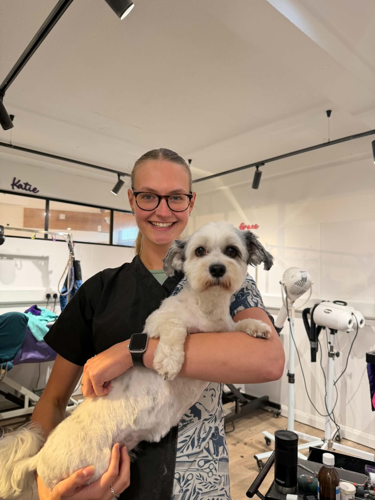 Portrait of Emily holding a small dog in the salon