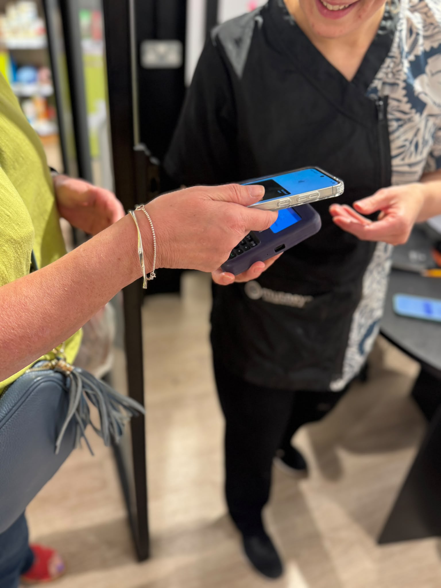 An owner paying by card at the salon reception after collecting her dog