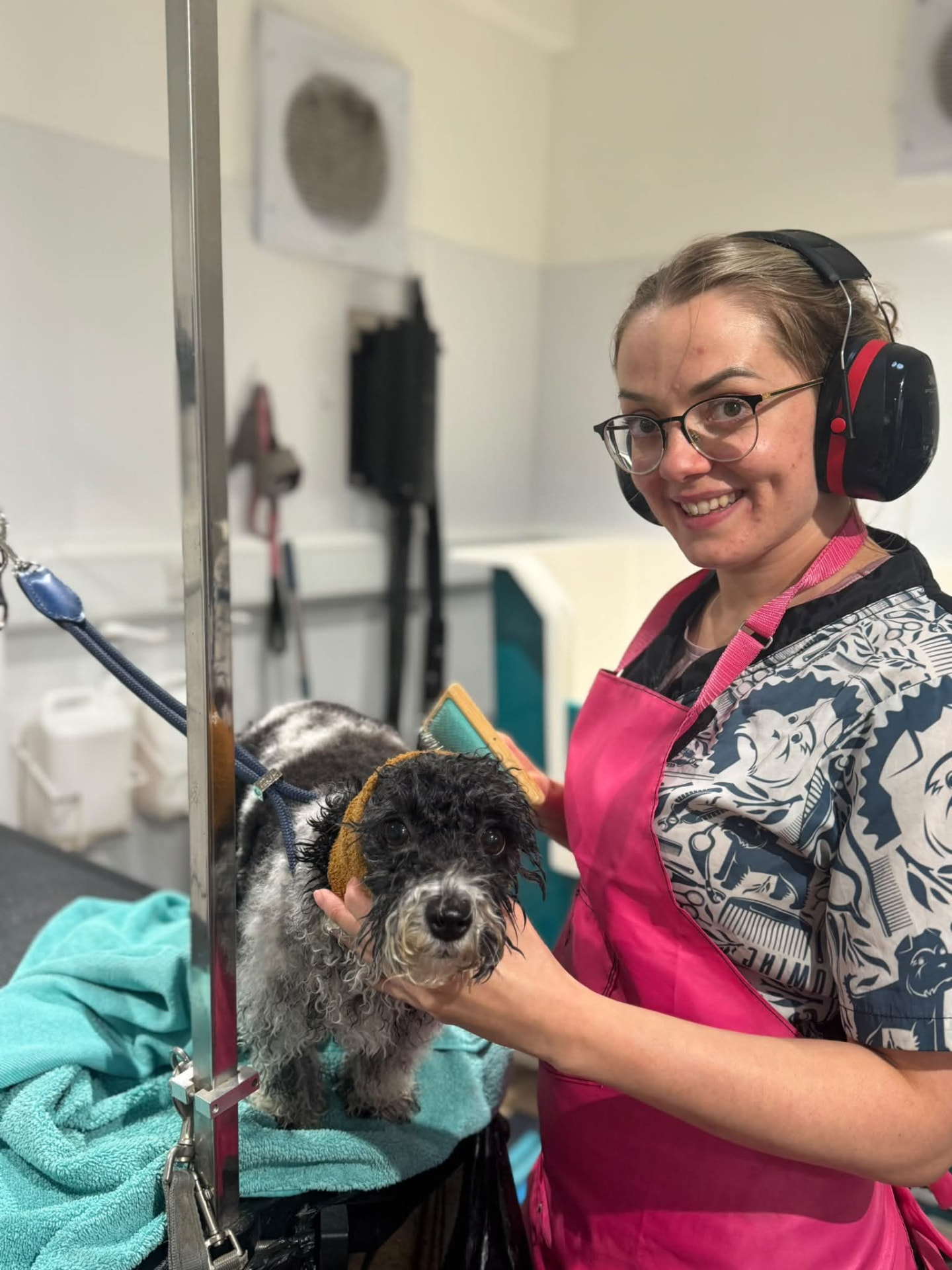 Portrait of Sacha at the grooming table with a freshly bathed dog